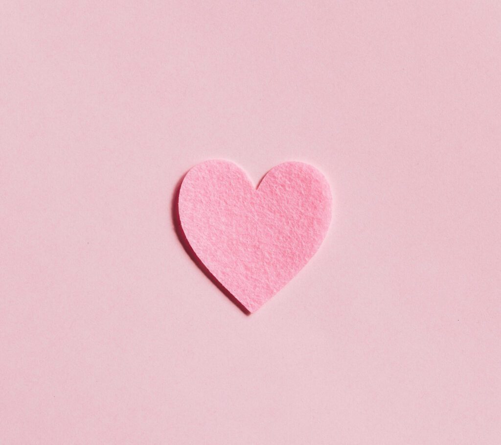 Pink heart-shaped cutout on a pastel pink background