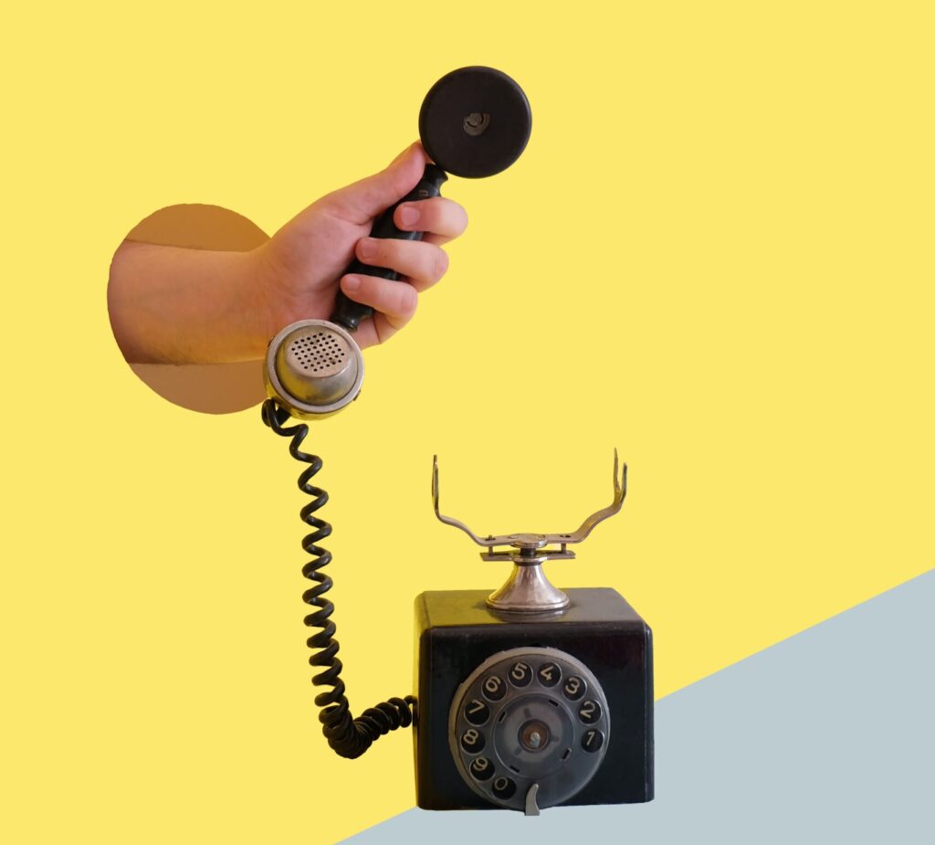 Hand holding a telephone receiver of a black dial-up telephone