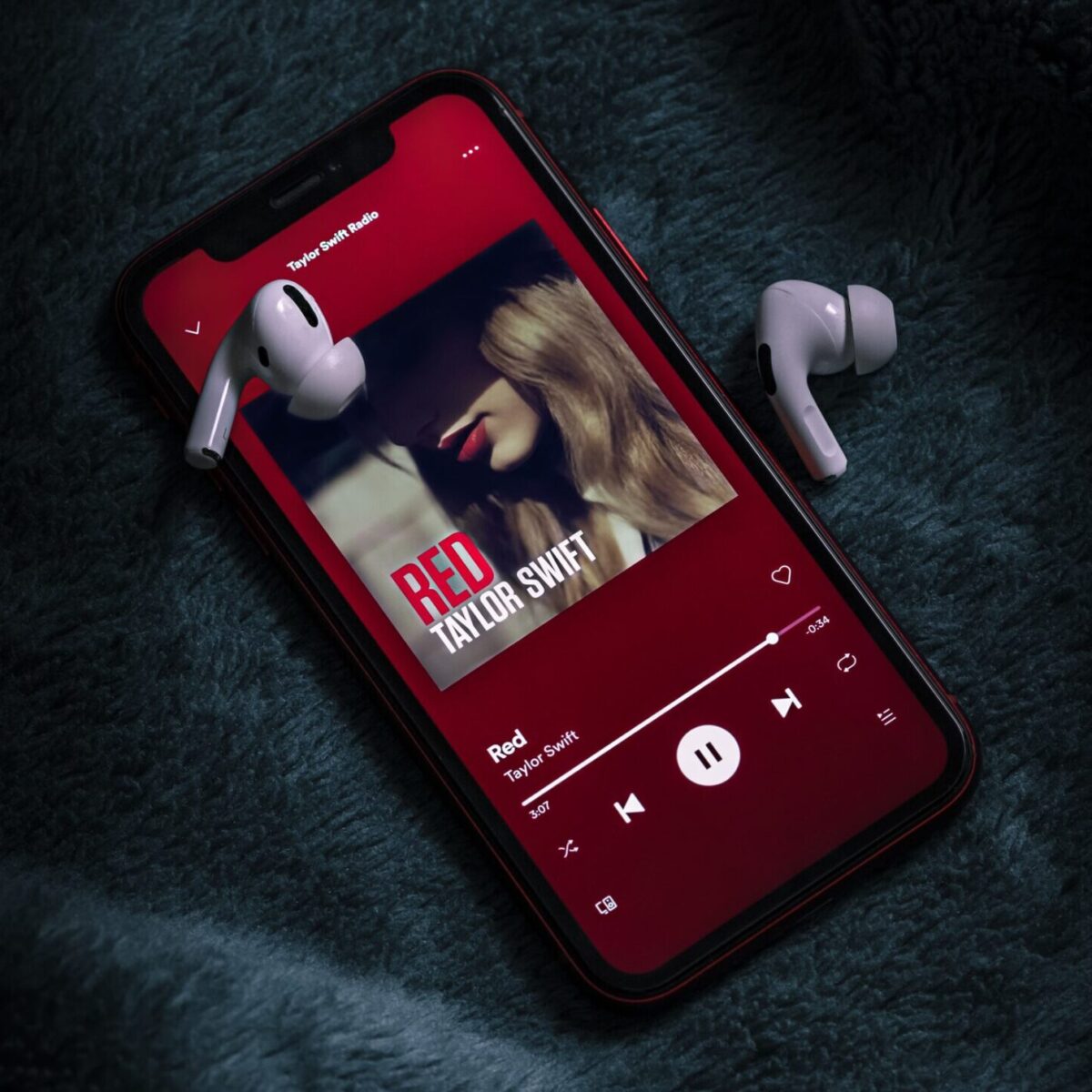 Touchscreen cellphone displaying the Spotify screen of Taylor Swift’s Red album