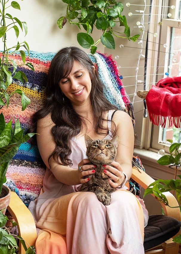 Paige Rechtman holding her cat Squiggles in an armchair